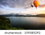Hot air balloons floating over lake