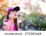 Lovely little asian girl blowing soap bubbles, Outdoor portrait