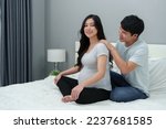 husband massaging shoulders of his pregnant wife on a bed. she suffering from back pain