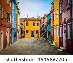 Colorful houses on a small traditional square at Burano island, Venice, Italy 