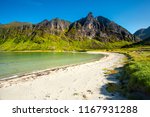 Norway. Senja island. Northern beach with white sand by the rocks. Summer norway landscape. Clear sunny day in Norway.