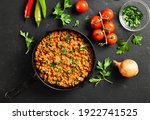Keema curry in frying pan over black stone background. Indian and pakistani style dish. Top view, flat lay