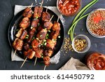 Bbq meat on wooden skewers on plate. Top view, flat lay