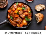 Goulash, beef stew in cast iron pan on dark background, top view, close up