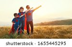 Small photo of concept of super family, family of superheroes at sunset in nature