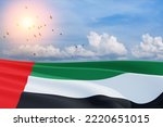 Small photo of Flag of United Arab Emirates on background of blue sky with flying birds. UAE celebration. National day, Flag day, Commemoration day, Martyrs day.