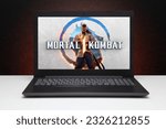 Small photo of Mortal Kombat 1 game on the screen laptop computer on black textured wall with orange light. Astana, Kazakhstan - July 2, 2023.