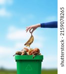 Small photo of Woman putting organic biodegradable waste in a recycling bin, separate waste collection concept
