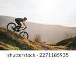 A man on a mountain bike rides downhill in beautiful nature.