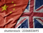 big waving national colorful flag of china and national flag of great britain . macro