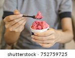 Closeup of woman's hands holding cup with organic frozen yogurt Ice cream served in a takeaway cup, Healthy eating concept.
