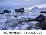 Rocks on beach of fjord of Norwegian sea in winteron sunset. Utakliev beach, Lofoten islands, Norway