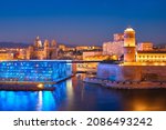 Marseille Old Port and Fort Saint-Jean and Museum of European and Mediterranean Civilisations and Marseille Cathedral illumintaed in night. Marseille, France. Marseille, France. Horizontal camera pan