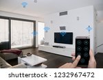 modern smarthome living room controlled by man holding a smartphone
