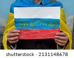 Small photo of Ukraine man holding poster with message economic sanctions for Russia. the collapse of the aggressor and the international theorist