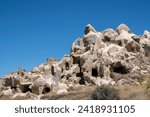 Small photo of typical rock formations of Cappadocia, with sandstone rocks of volcanic origin eroded in a capricious way by water, and caves dug in them, horizontal