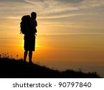 Small photo of A walker admires the sunset at the end of a day from Emmett's Hill on the Jurassic Coast of Dorset.