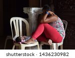 Small photo of San Pablo City, Laguna, Philippines - June 21, 2019: Sleeping mendicant woman let her newborn baby lay on chair at church portal.