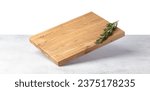 Small photo of Cutting board falling on a grey stone table. Isolated on a white background. Culinary background. Empty wooden cutting board, product display space.
