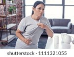 Small photo of High temperature. Joyless cheerless woman sweating and drinking water