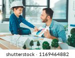 Small photo of Color map. Joyful brunette man keeping smile on his face while looking at his kid