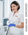 Small photo of Pretty doctor holds applicator of BTL 600 device in her hands