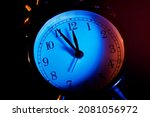 Five minutes to midnight. Changing the clocks, time adjustment, daylight savings or new year concept on retro analog clock, close up