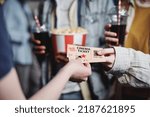 Unrecognizable people giving tickets for movie to cinema worker to enter hall, selective focus shot