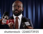 Small photo of Confident African American male deputy or delegate in formalwear answering questions of journalists at press conference