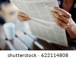 Small photo of Newspaper broadsheet held and read by senior female