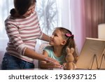 mother and daughter doing... | Shutterstock . vector #1936937125
