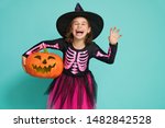 Happy Halloween! Cute little witch with a pumpkin on turquoise background.