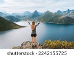 Traveler woman in Norway hiking success raised arms on the top of mountain Travel adventure active vacations outdoor healthy lifestyle. Senja island