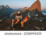 Family father and child sitting in camping chairs outdoor traveling in Norway mountains dad with daughter hiking together adventure vacations lifestyle sunset Segla mountain landscape