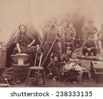 The Civil War, woman with sleeves rolled up holding basket, with a soldier and three children, soldiers in the background, camp of 31st Penn Infantry near Washington DC, photograph, February, 1862.