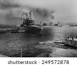 USS California lists after aerial blows taken during the Japanese attack on Pearl Harbor. In distance the USS Neosho, cautiously backs away from berth, avoiding capsized USS Oklahoma. Dec. 7, 1941.