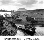 Vehicles of war knocked out on the black sands of the volcanic island of Iwo Jima. They were smashed by Japanese mortar and shellfire. Ca. March 1945.