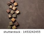 chocolates praline variety on brown background with copyspace