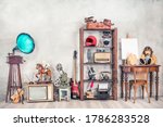 Antique media devices, writers tools, gramophone, film projector, old Teddy Bear toys and white canvas blank on easel, violin and guitar front concrete wall background. Vintage style filtered photo