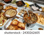 Small photo of Barcelona, Spain – April 18, 2018: Horizontal high angle view of some ready meals in a stall of the old Abaceria Central Market in the Gracia neighborhood