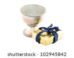 Small photo of Golden gift box and old metal sneezer over white background.