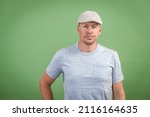 Small photo of frenchman with gray cap and gray shirt against green background