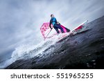 Small photo of A windsurfer tilts the rig and carves the board to perform a planing or jibe