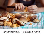 Woman Cleaning Wild Mushrooms...