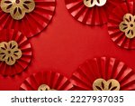 Frame of red paper fans with gold flowers on red background. Happy Chinese New Year 2023 concept.