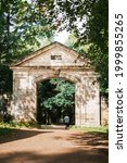 Small photo of Gatchina, Saint-Petersburg, Russia, 25 August 2020: 'Silvian Gate', was built at the end of the 18th century, author is V. Brenna. The mask of the bearded 'Forest God' is carved above the arch.