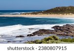 Small photo of Tide ebbing out from the famous white sandy surfing beach and rocky shore at Margaret River, South Western Australia on a calm clear sunny afternoon in early summer creates a scenic seascape.