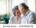 Healthy Asian older people laughing and relaxing at their house together. Happy smiling Elderly man and woman celebrating Anniversary. Joyful senior couple in love. Copy space.