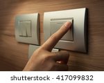Small photo of Close up of male finger is turn off on grey button of light switch over wood wall at home. Power, Energy, Saving Electrical.