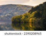 mountainous autumn landscape with lake at sunset. scenery in fall colors reflecting in the calm water